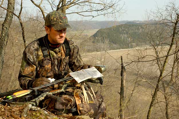 hunter reading a map on a ridgetop
