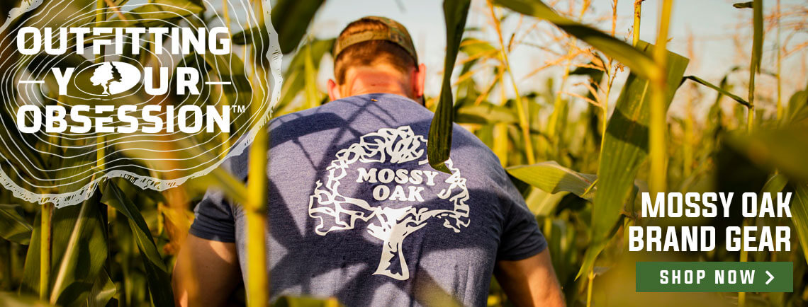 mossy oak brand gear: a man walking through corn stalks
