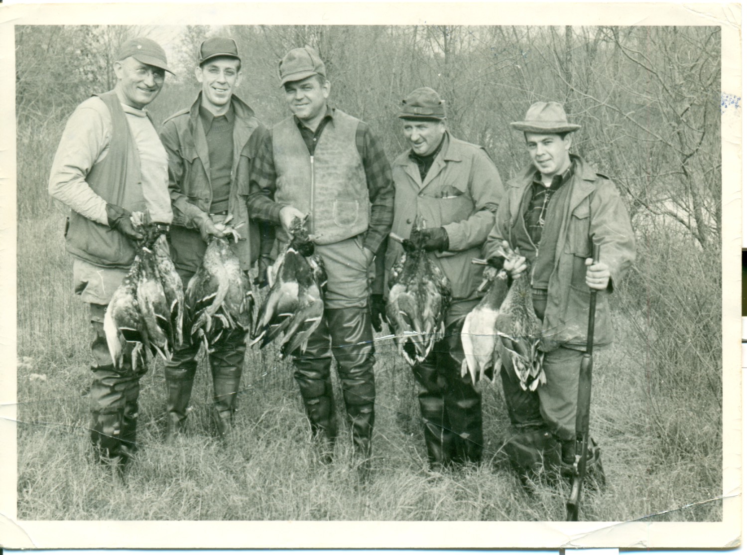 old photo of five men holding up ducks, circa 40s