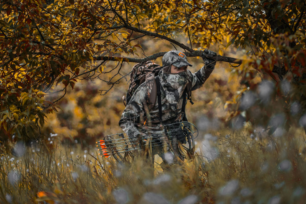 bowhunter walking to tree stand
