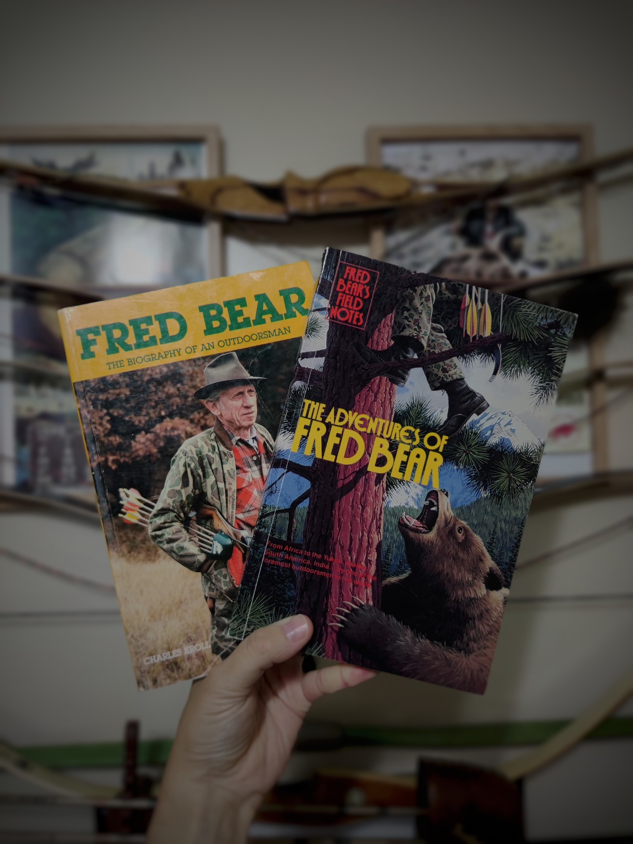 the Fred bear biography and field notes held in the air