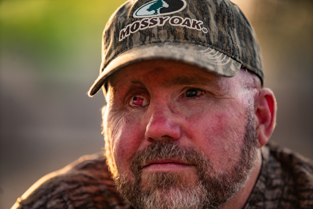 close up of Joe bogart's face; his right eye is a glass eye with an American flag