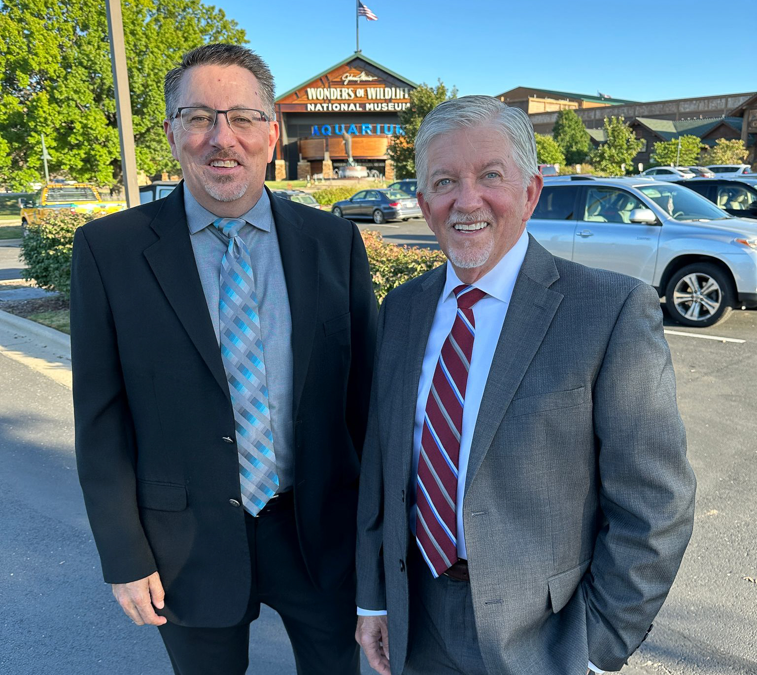 mark and Terry Drury stand together in suits