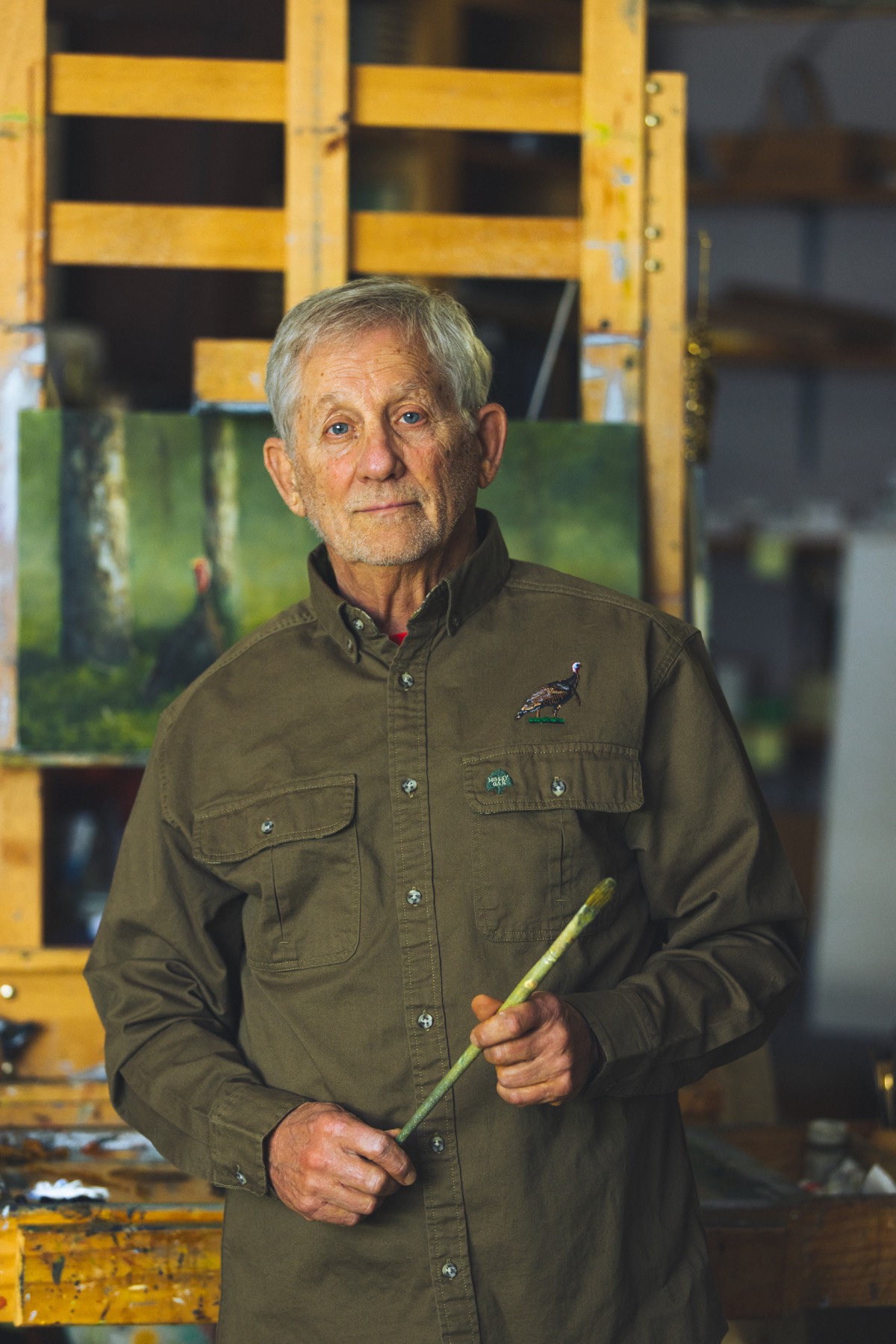 bob Tompkins stands with paintbrush