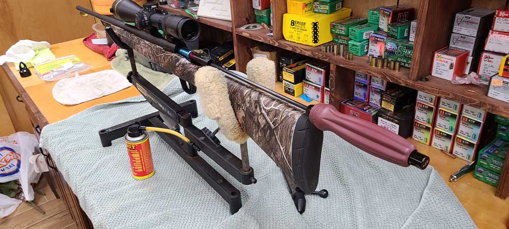 cleaning rifle on stand
