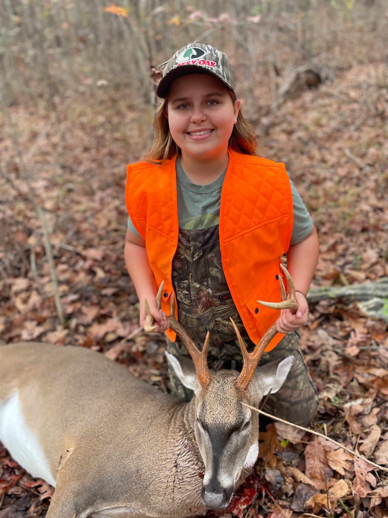 young girl poses with buck