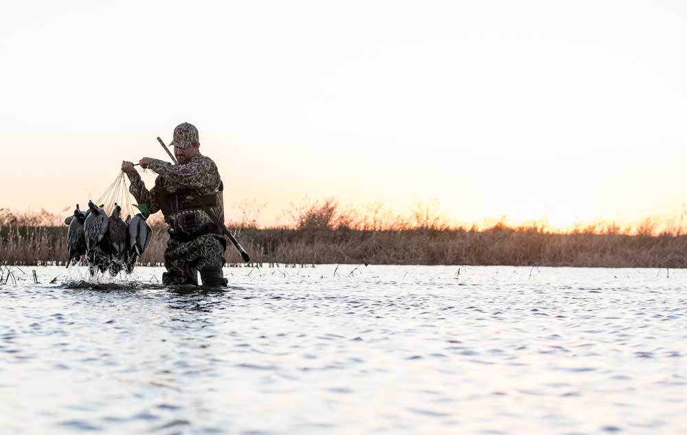 duck hunter carrying decoys