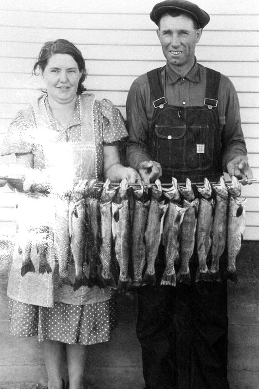 finis Mitchell and his wife stand with a string of trout