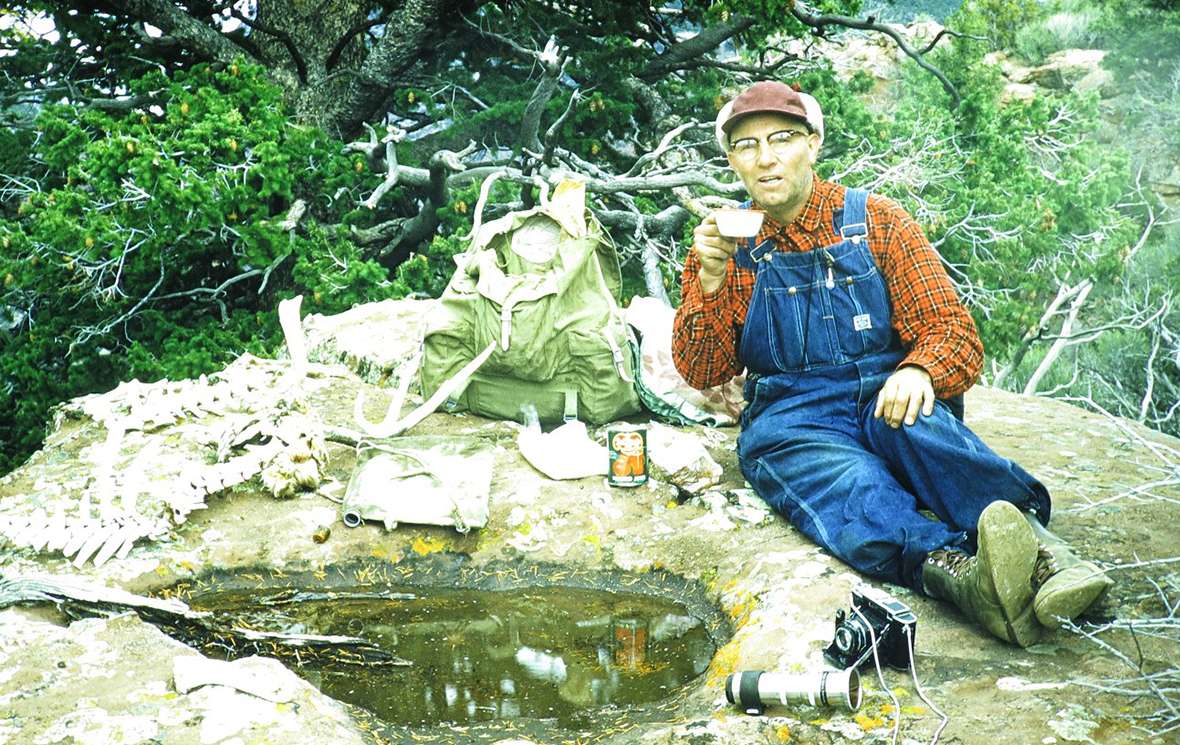 Mitchell rests on a rock next to his gear