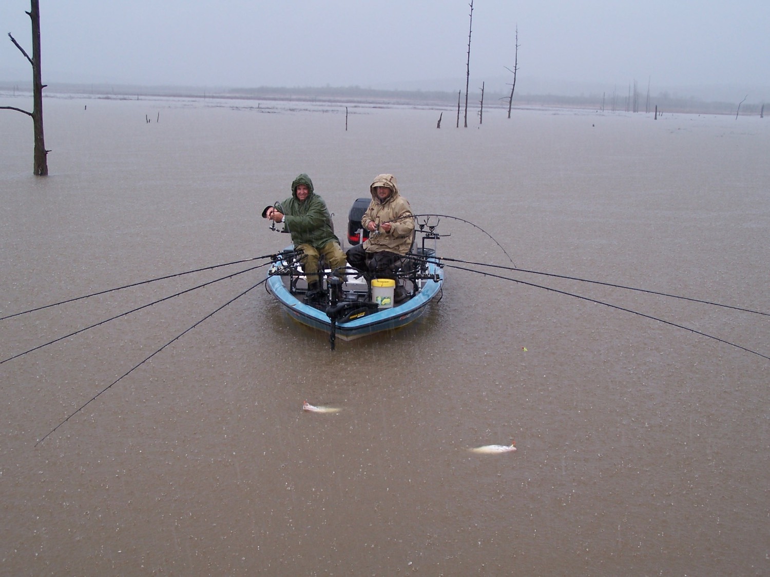 two men fish in heavy rain