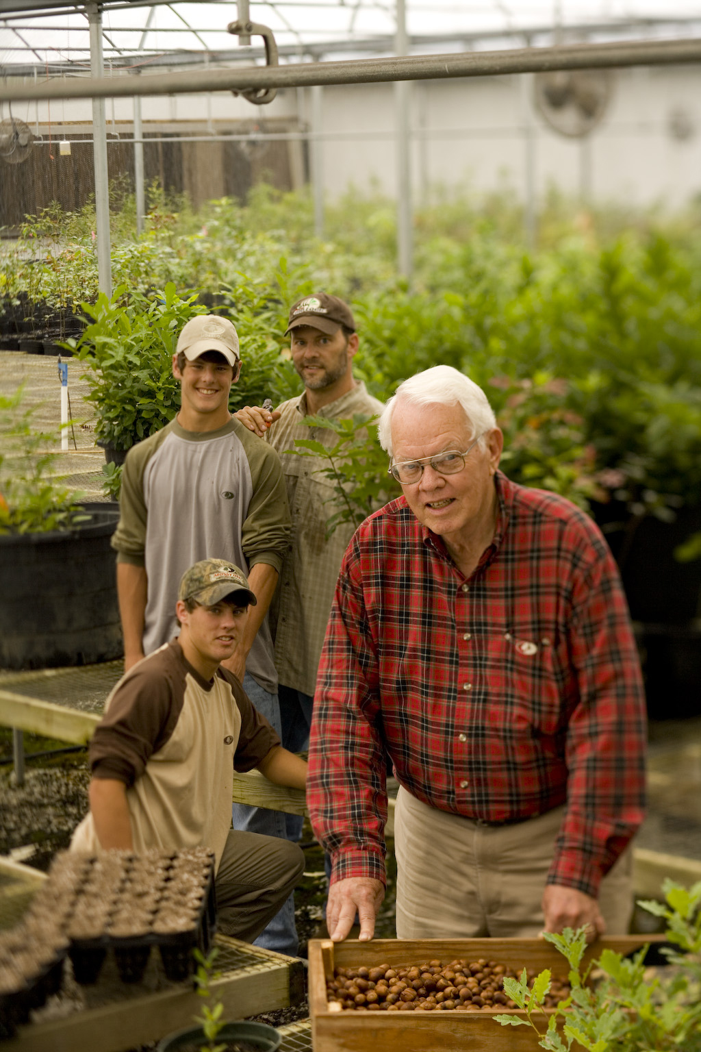 fox haas and his son and two grandsons stand in a tree nursery