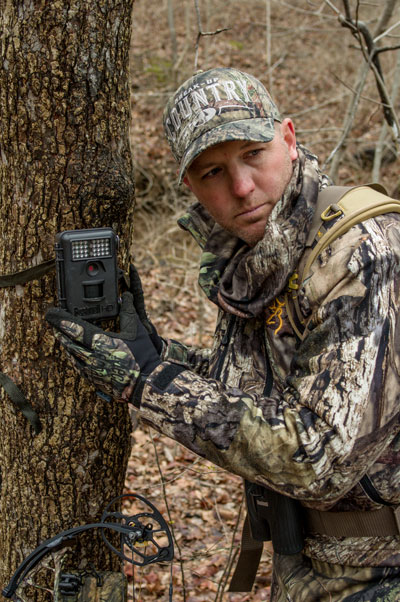 hunter checking trail camera