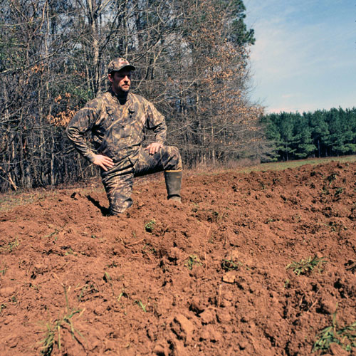 hunter over hog rutted field