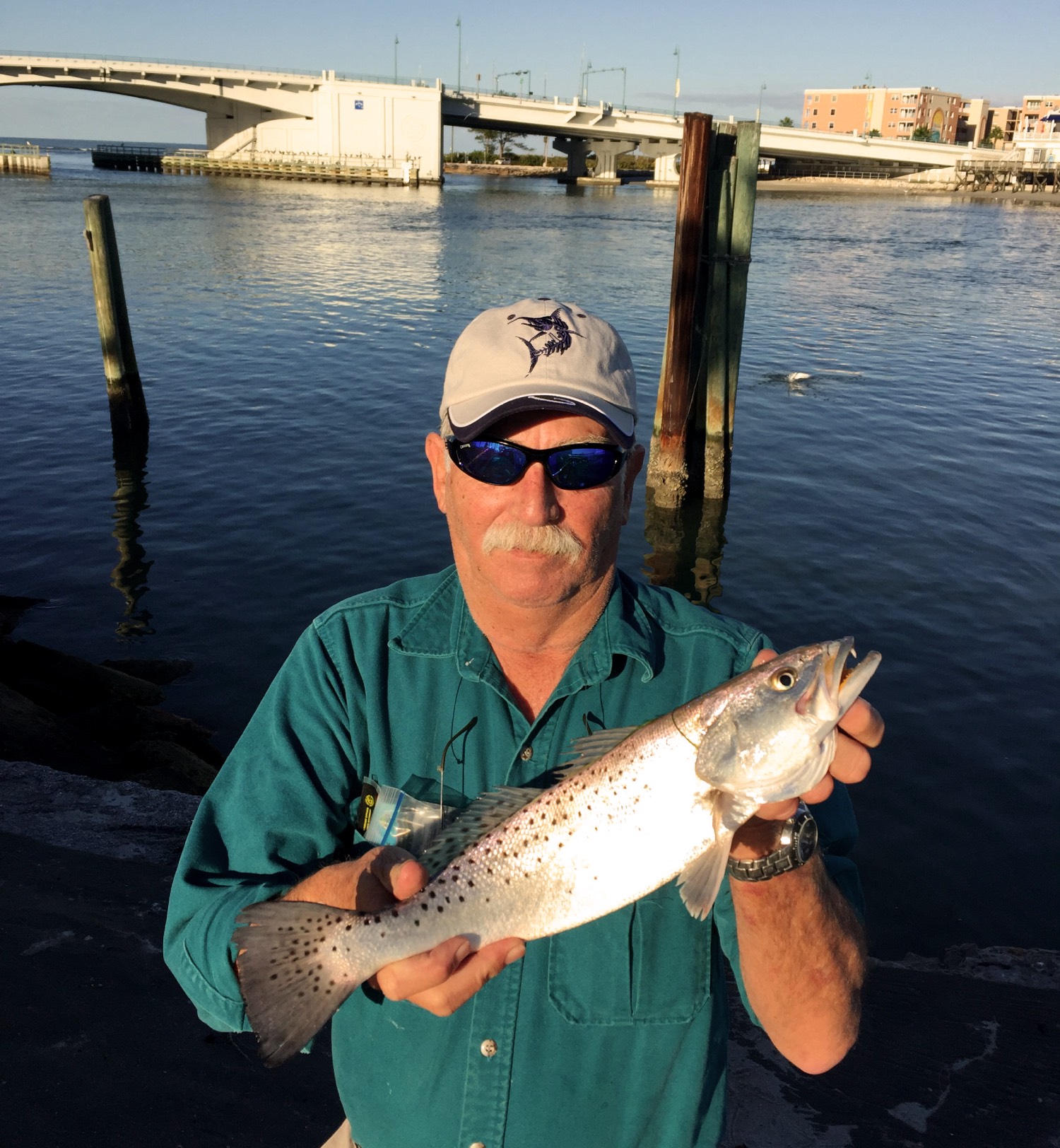 man holds up a speckled trout