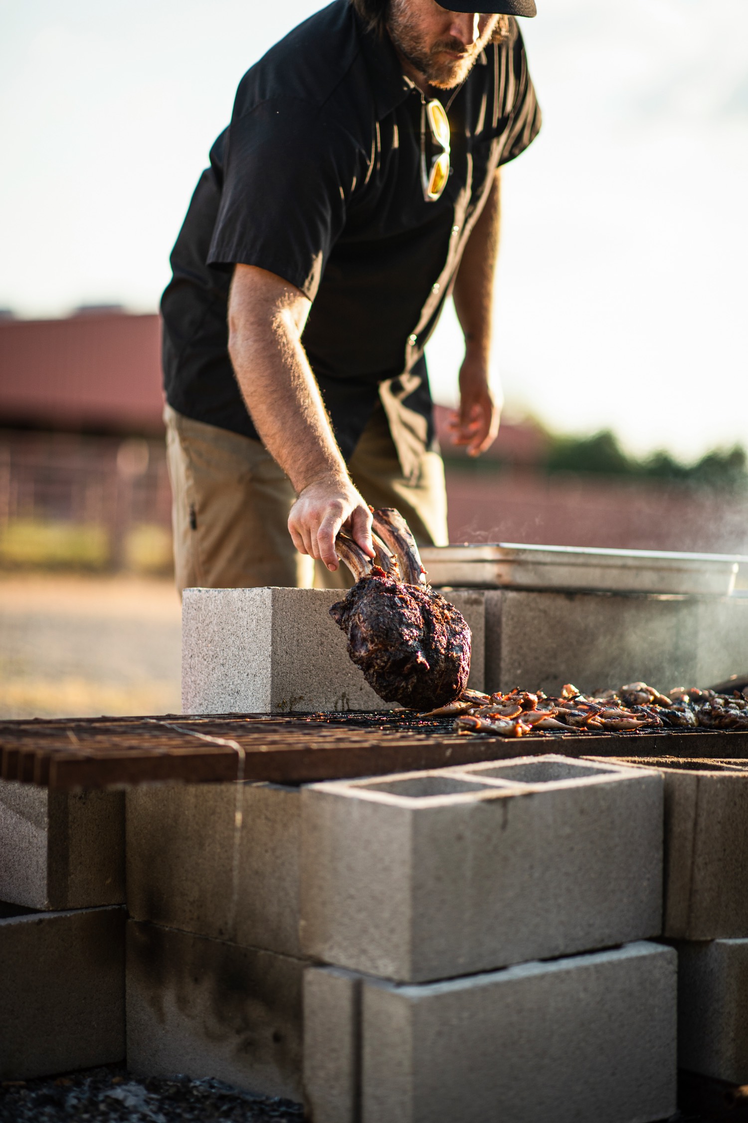 man places meat on a grill