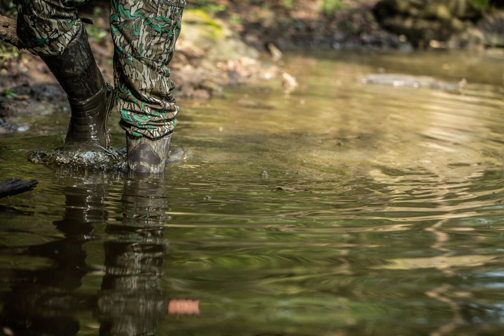 hunter walking through stream