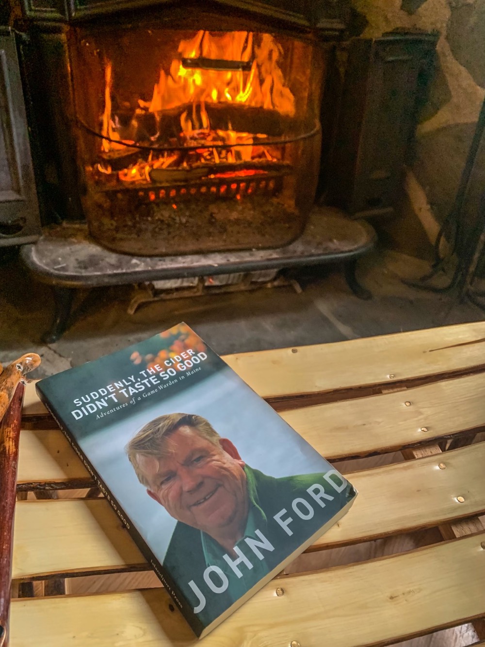 the book sits in front of a cabin's fireplace