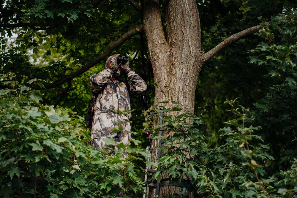 hunter in treestand binoculars