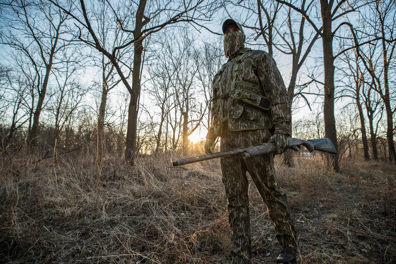 man walking in the woods in camo