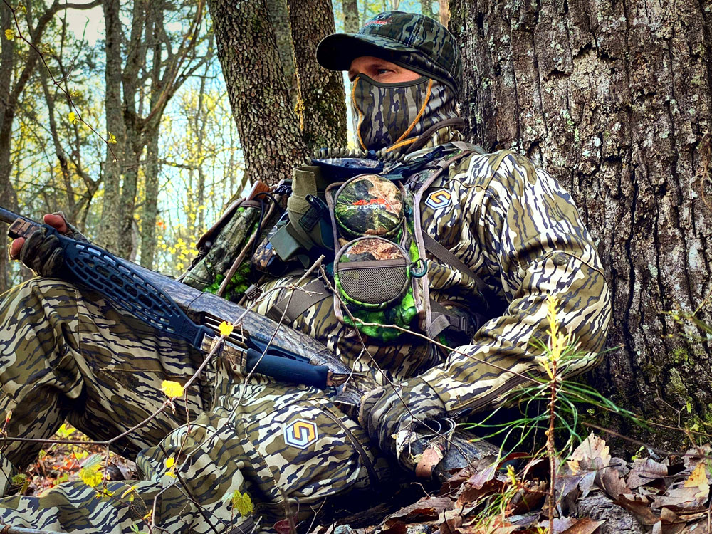 turkey hunter against a tree