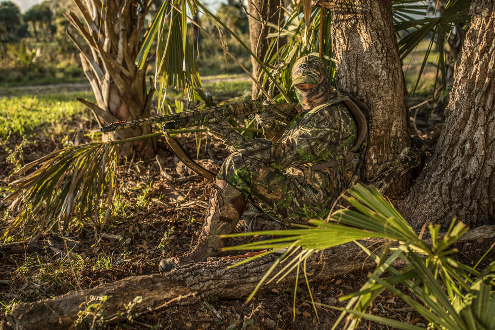 turkey hunter sitting by tree