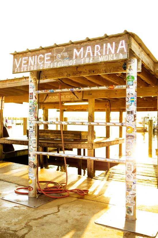 the iconic Venice marina sign: a place to hang fish and a wooden sign that says "Venice marina"