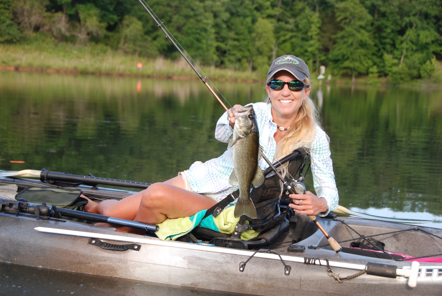 woman in a kayak holding up a fish