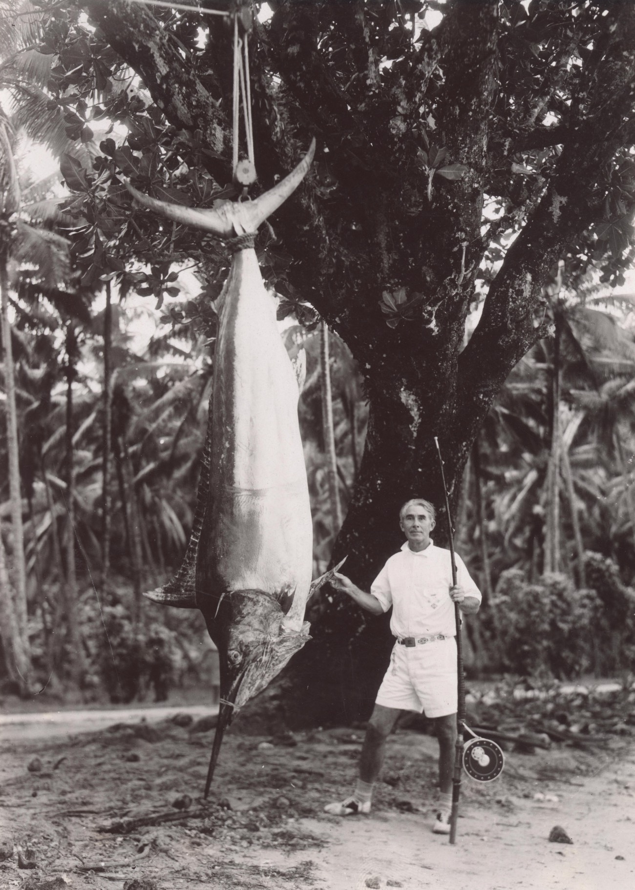 black and white photo of man holding fish